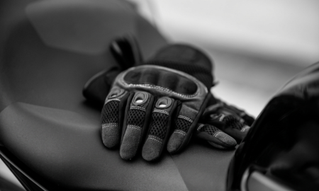 Biker gloves placed on a bike closed image