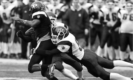 An AFL game scene with a player tackling another player while playing game